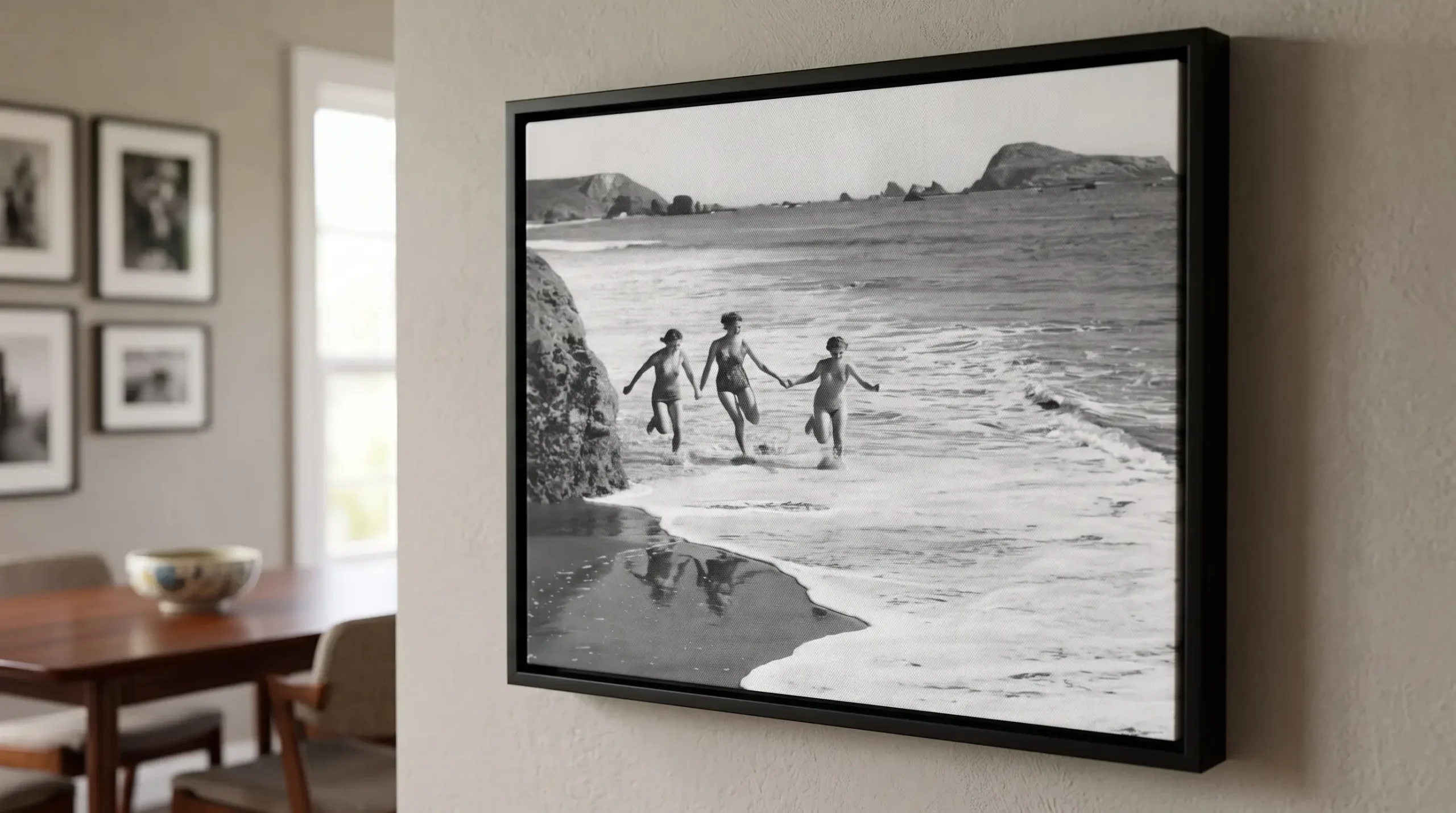 Black and white family beach photograph displayed as a premium framed canvas print with a black timber floating frame.